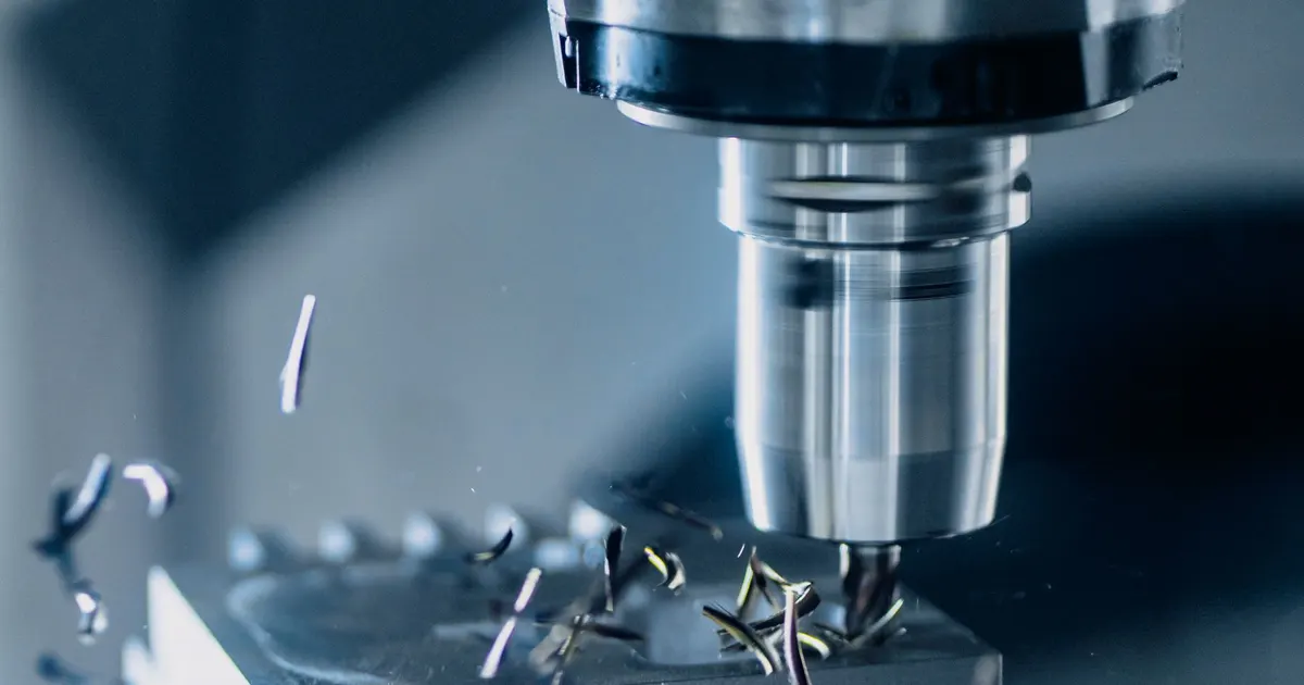 CNC machining center cutting a metal block with chips flying, illustrating milling of bicycle components