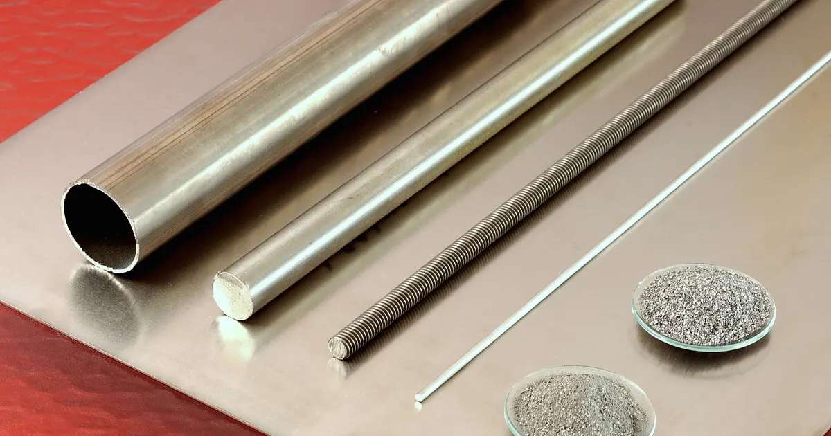 Titanium plate, tube, rods and powder arranged on a red surface, showing common forms of titanium stock