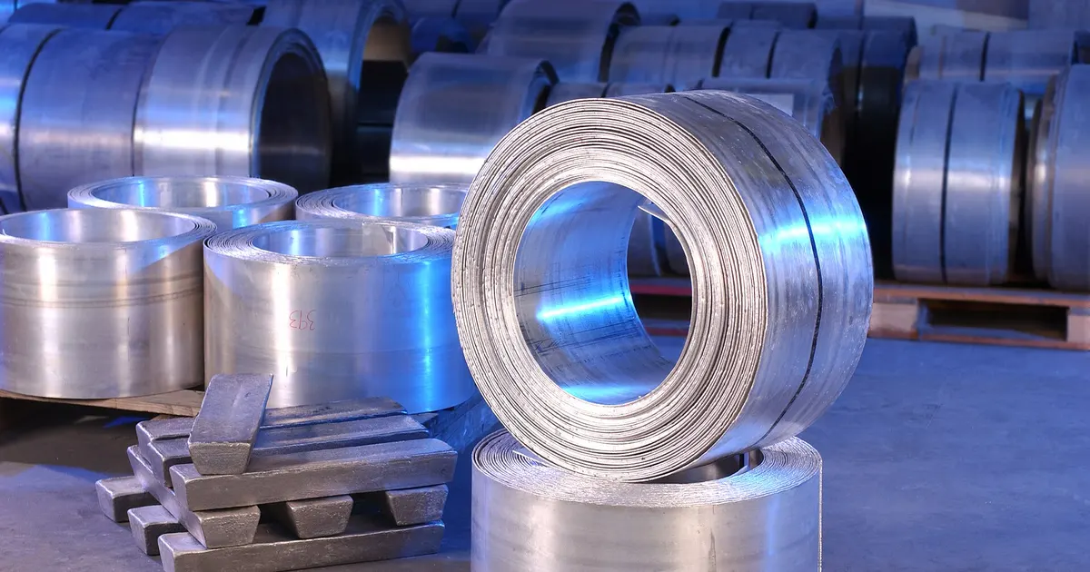 Coiled magnesium sheet and magnesium ingots stacked on pallets in a materials laboratory